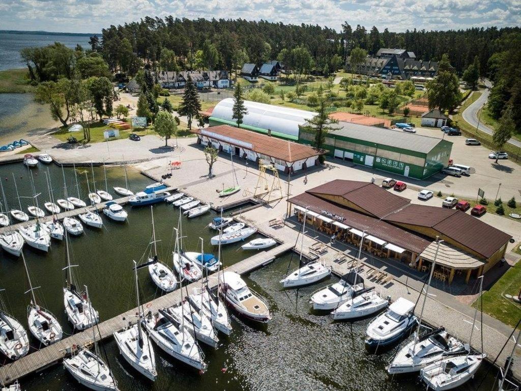 Un tas de bateaux sont amarrés dans un port de plaisance dans l'établissement AZS Centralny Ośrodek Sportu Akademickiego, à Wilkasy