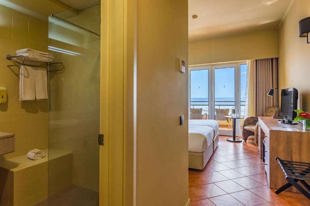 a hotel room with a bed and a bathroom at Calheta Beach - All-inclusive - Savoy Signature in Calheta