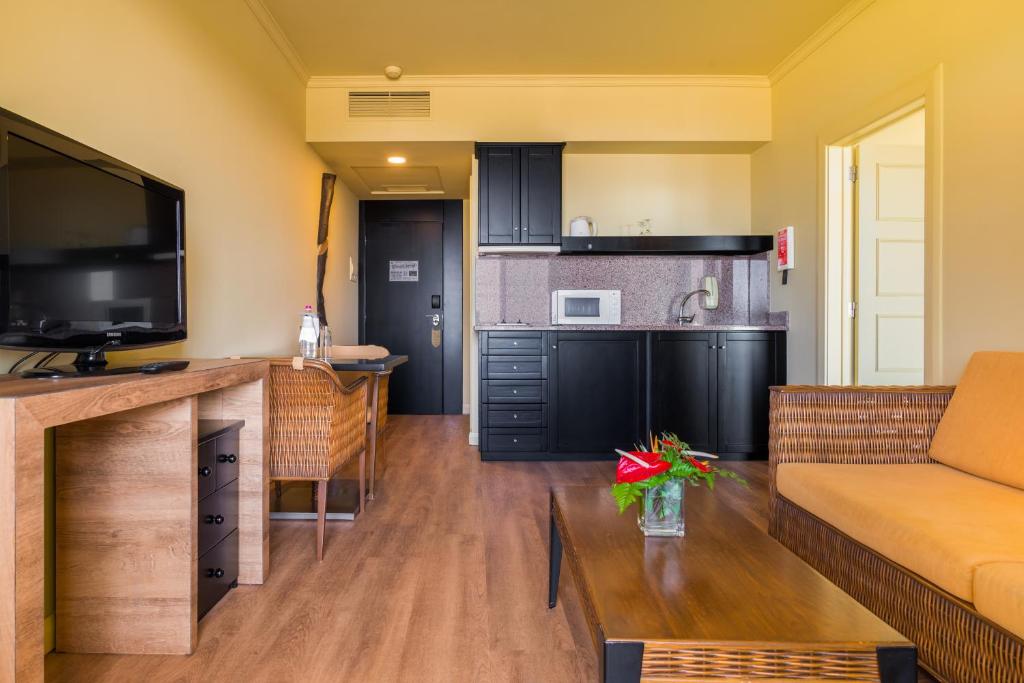 a living room with a couch and a kitchen at Calheta Beach - All-inclusive - Savoy Signature in Calheta
