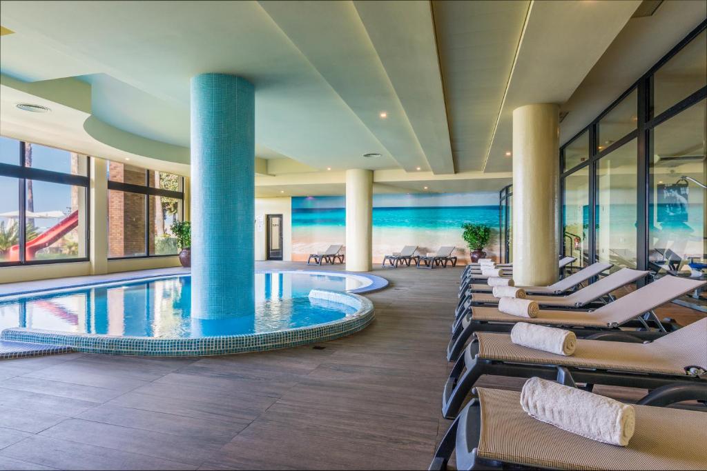 a hotel lobby with a pool and lounge chairs at Calheta Beach - All-inclusive - Savoy Signature in Calheta