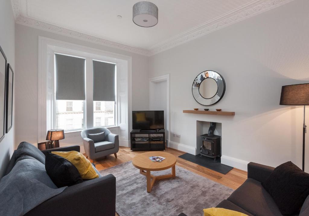 ein Wohnzimmer mit einem Sofa und einem Tisch in der Unterkunft The Brunswick Street Residence in Edinburgh
