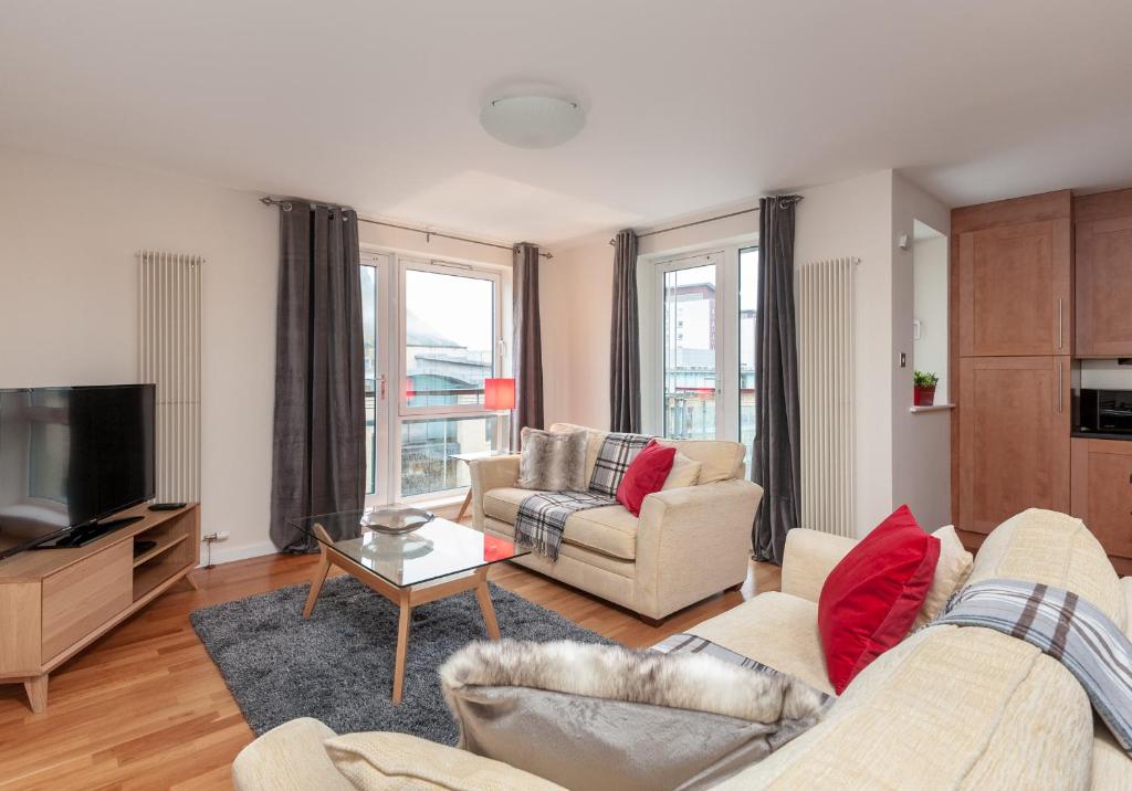 a living room with two couches and a tv at The Holyrood Park Residence in Edinburgh