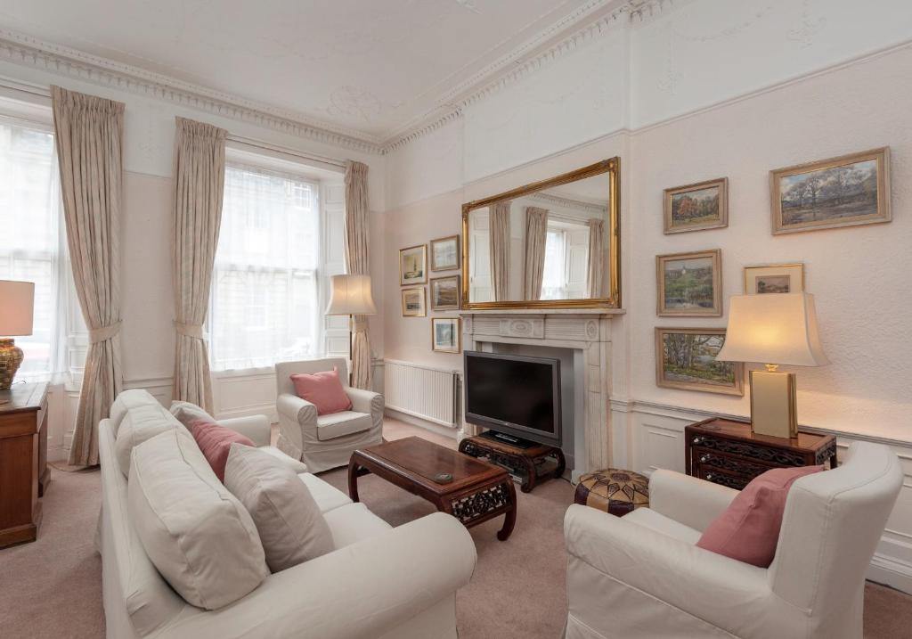 een woonkamer met witte meubels en een open haard bij The Hart Residence in Edinburgh