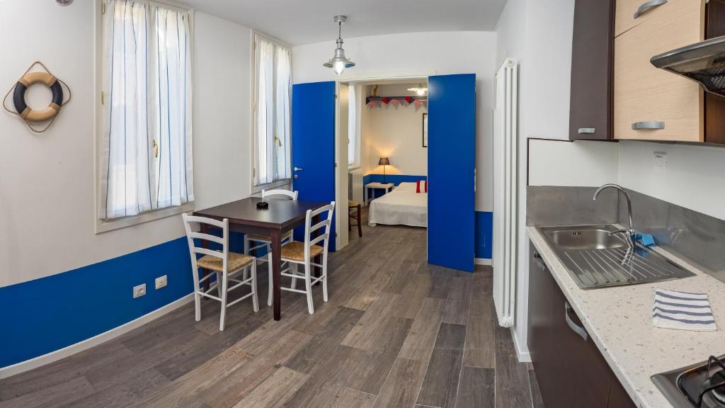eine Küche mit einem Tisch und ein Zimmer mit einem Bett in der Unterkunft A la Pescarìa Studios in Venedig
