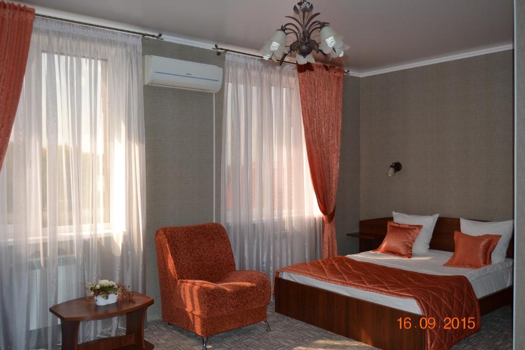 ブズルクにあるHotel Complex Druzhbaのベッドルーム1室(ベッド1台、椅子、窓付)