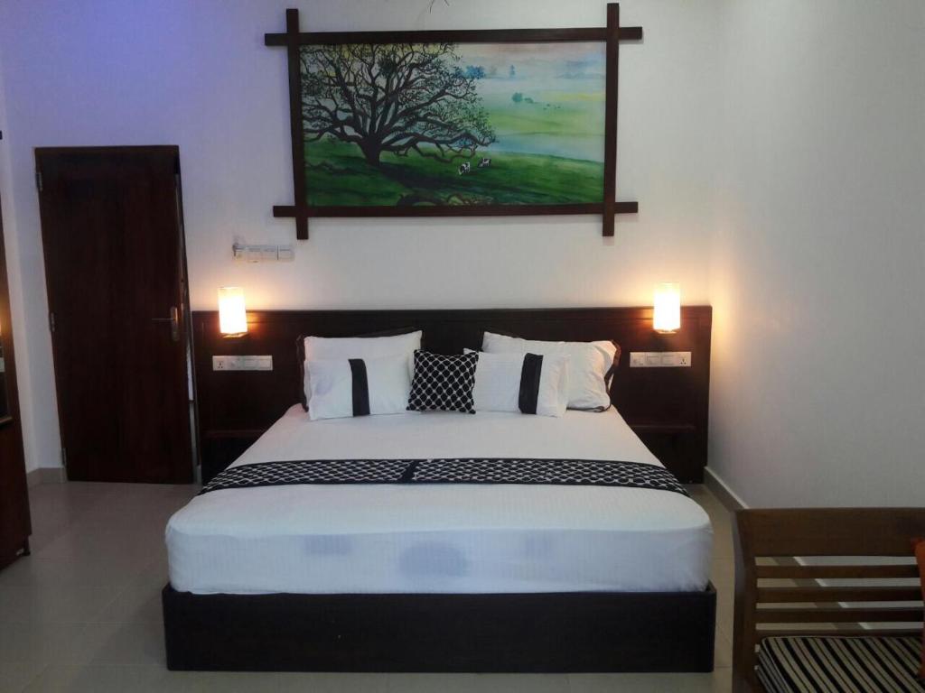 a bedroom with a large bed with a painting on the wall at Dedunu Home Bentota in Bentota