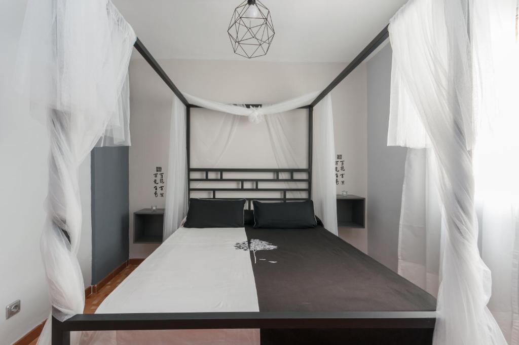 マドリードにある32 Marques Realの白いカーテンが備わるドミトリールームのベッド1台分です。