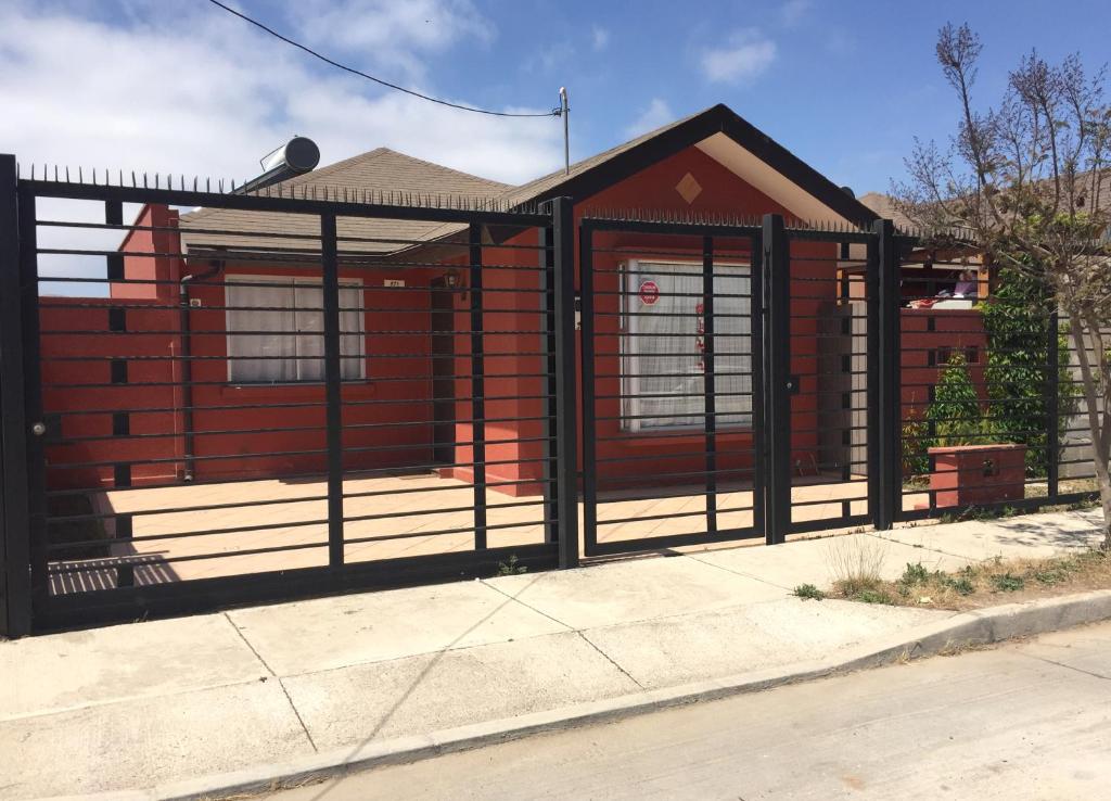 ein Haus mit einem Tor davor in der Unterkunft Casa Familiar La Serena in La Serena