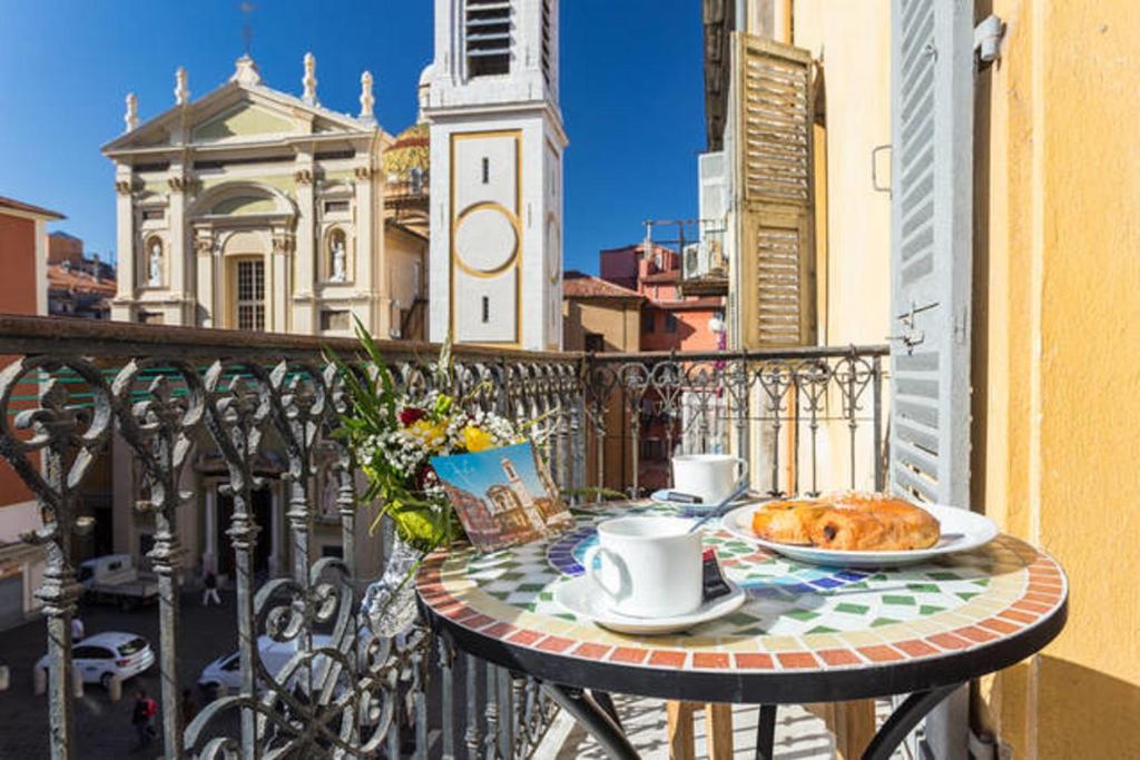 - une table sur un balcon avec un petit-déjeuner composé de café et de croissants dans l'établissement LE ROSSETTI B. - modern, long balcony, old town Nice, à Nice