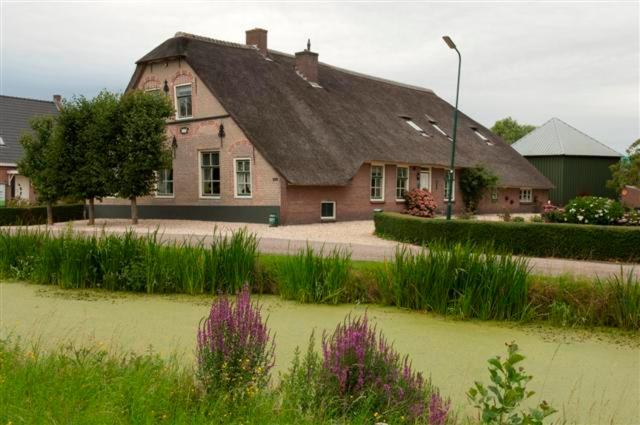 une grande maison en briques avec un toit dans l'établissement Apud nos Domi, à Polsbroek