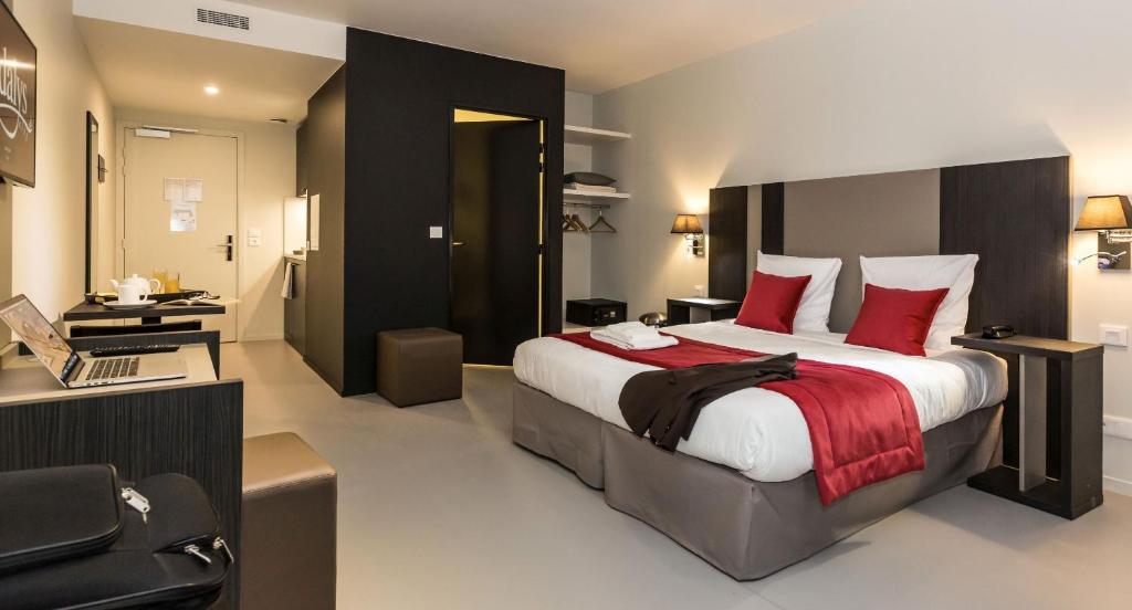 um quarto com uma cama grande e almofadas vermelhas em Odalys City Paris XVII em Paris