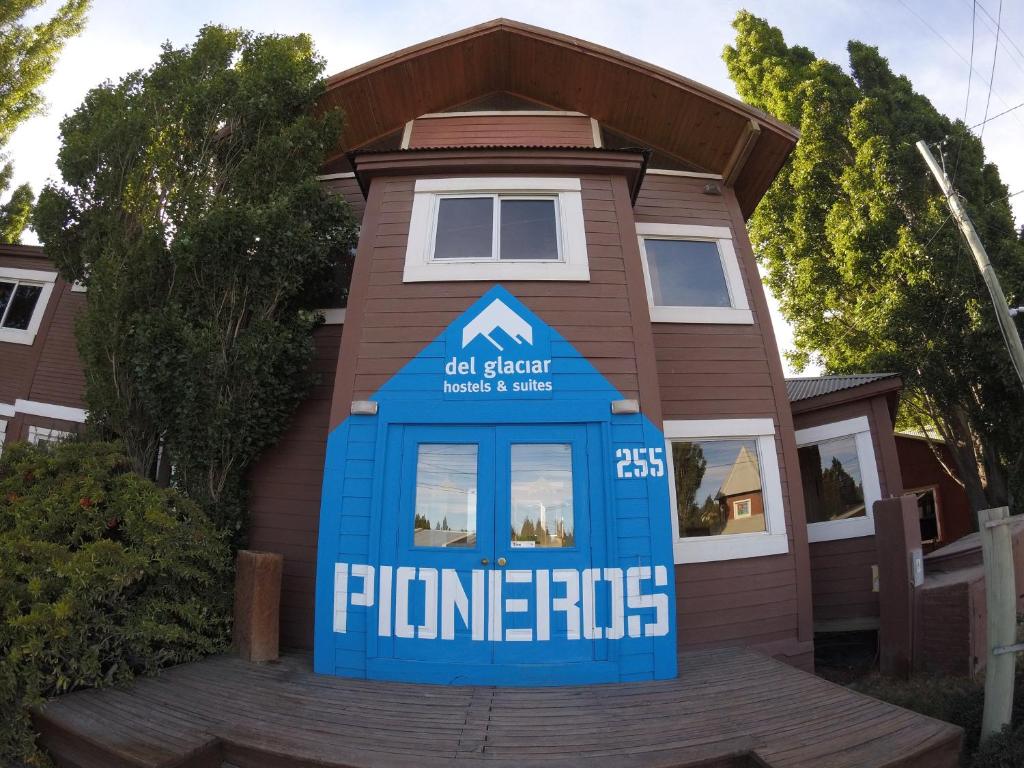 een huis met een blauwe telefooncel ervoor bij Hostel Los Pioneros in El Calafate