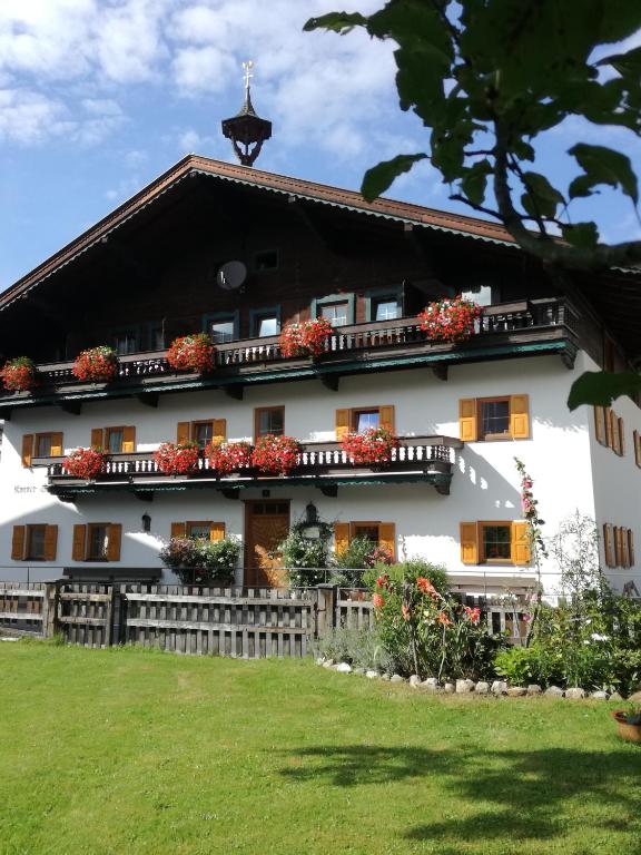 duży biały budynek z kwiatami na balkonach w obiekcie Karrerhof w mieście Walchsee