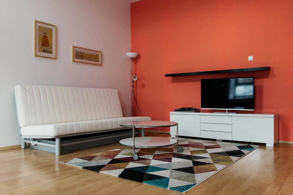 Televízia a/alebo spoločenská miestnosť v ubytovaní Apartamenty „Lofty w piecowni”