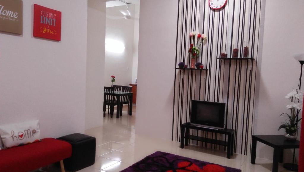 MaiHomestay Seri Iskandar في سيري إسكندر: غرفة معيشة مع أريكة حمراء وتلفزيون