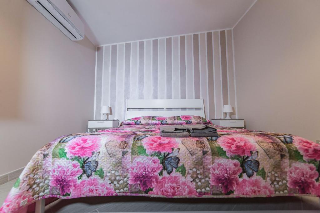 ポルト・エンペードクレにあるB&B Villa Marikaのピンクの花が飾られたベッドルーム1室