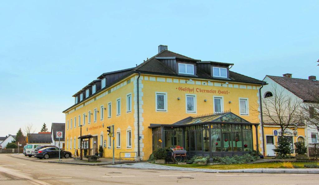 ein gelbes Gebäude an der Ecke einer Straße in der Unterkunft Hotel-Gasthof Obermeier in Allershausen