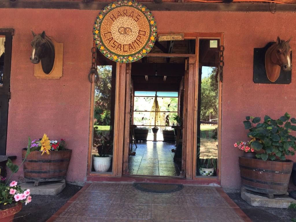 an entrance to a building with a horse on the wall at Hotel Haras Casacampo in Quintero