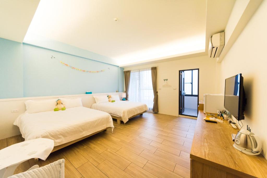 ein Hotelzimmer mit 2 Betten und einem Flachbild-TV in der Unterkunft Ting Shuan B B&B in Suao