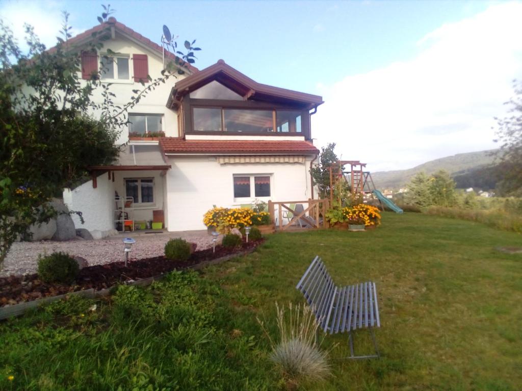 una casa en una colina con una silla en el patio en Gîte De La Belle Vallée en Cleurie