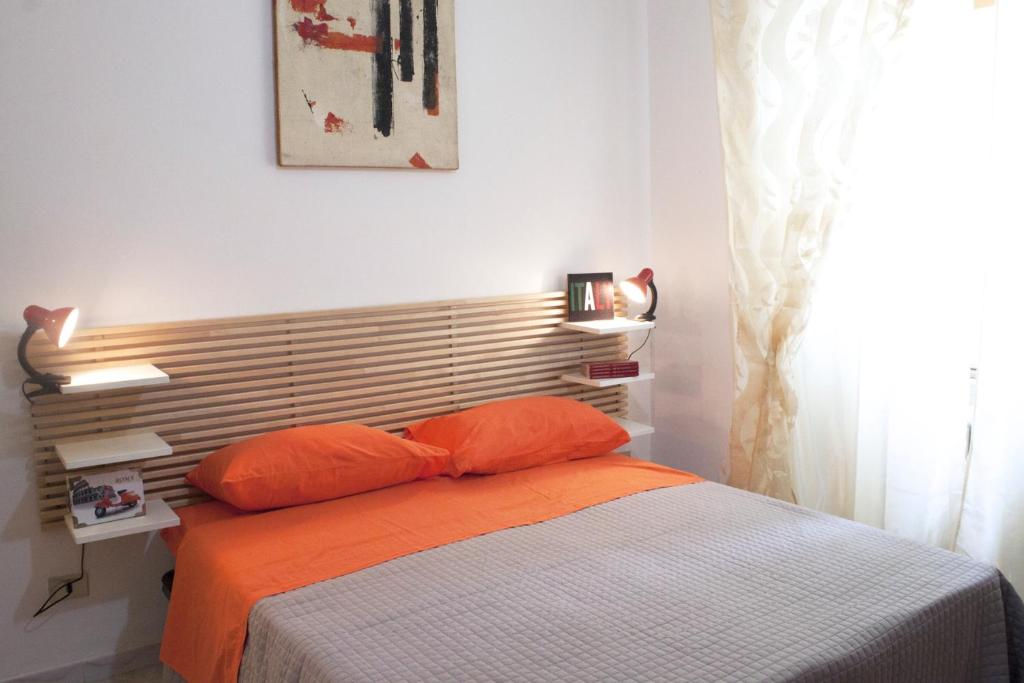 a bed with orange pillows in a bedroom at Il Pozzo in Rome