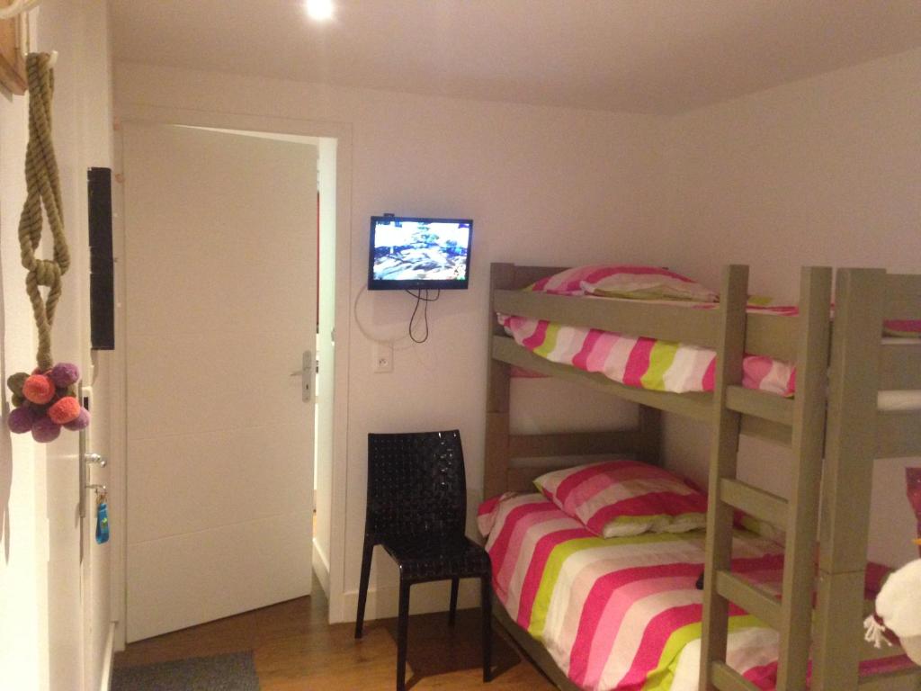 フレーヌにあるFlaine Forum K2 Cassiopéeのベッドルーム1室(二段ベッド2台、テレビ付)