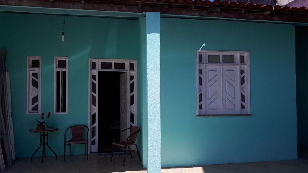 ein blaues Haus mit zwei Stühlen und einer Tür in der Unterkunft Hospedagem Vovó Gina in Aracaju