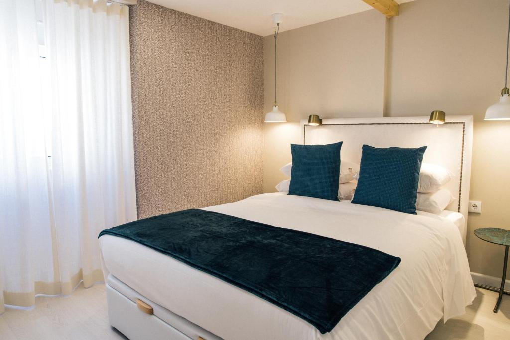 a bedroom with a large white bed with blue pillows at Canarios Apartments Avenida in Lisbon
