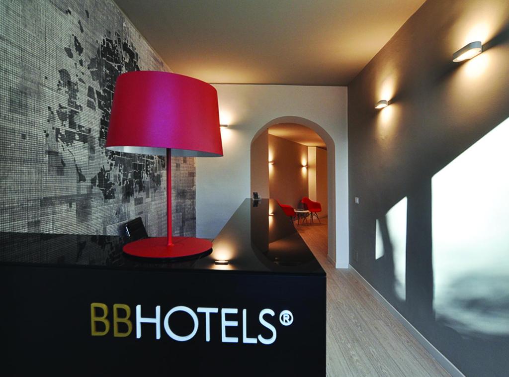 une lampe rouge sur une table dans une pièce dans l'établissement BB Hotels Aparthotel Città Studi, à Milan