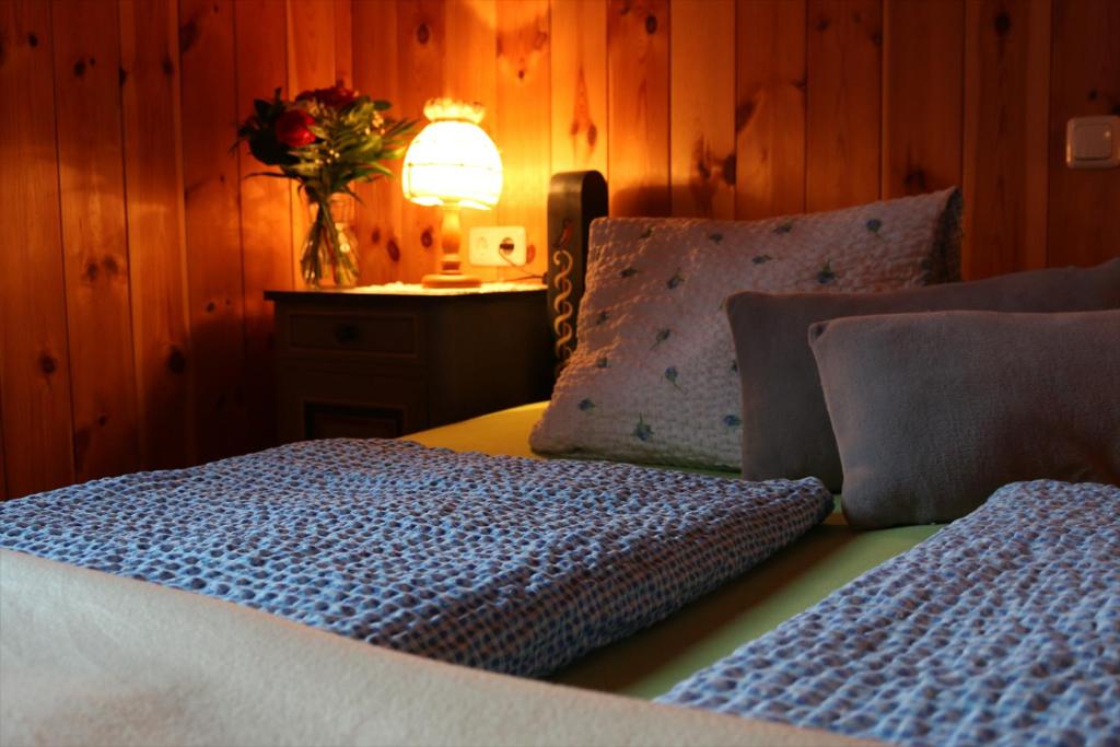 een slaapkamer met een bed en een lamp en een vaas met bloemen bij Ferienhaus am Mühlbach in Gams bei Hieflau