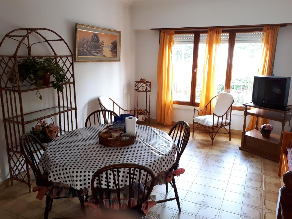 comedor con mesa, sillas y TV en Apartamento con quincho y parrilla en Mar del Plata