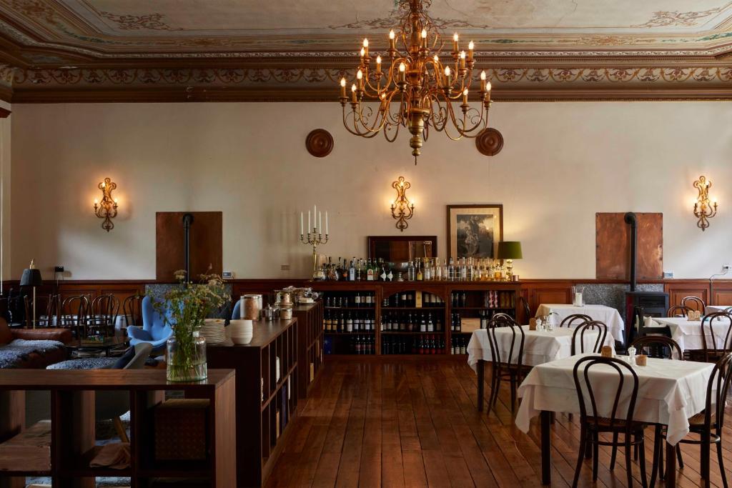 una sala da pranzo con tavoli, sedie e lampadario a braccio di Hotel Monterosa ad Alagna Valsesia