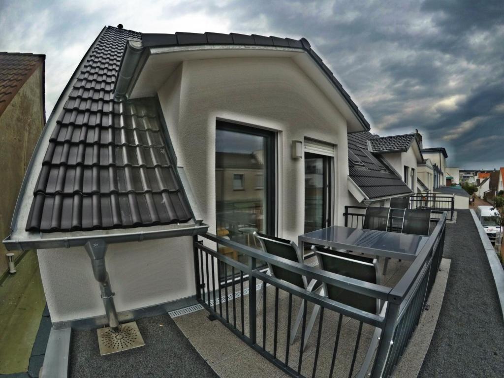 einen Balkon eines Hauses mit einem Tisch und Stühlen in der Unterkunft Fewo Durak in Norderney