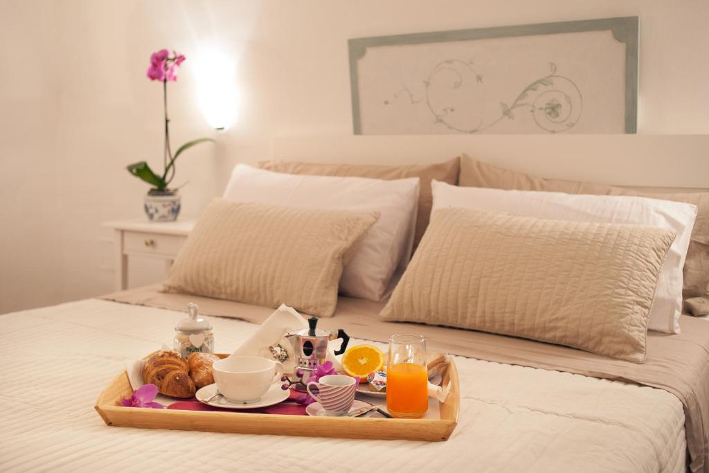 ナポリにあるNiloufar residenceのベッドの上に朝食トレイ(オレンジジュース付)