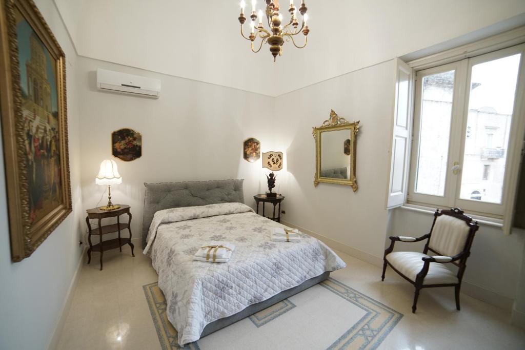 マテーラにあるDimora del Sedileのベッドルーム1室(ベッド1台、椅子、シャンデリア付)