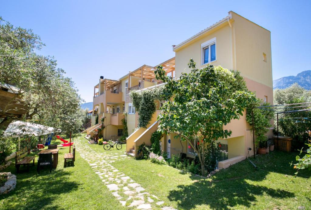 an apartment building with a garden in the middle of a yard at Antheon Villas in Chrysi Ammoudia