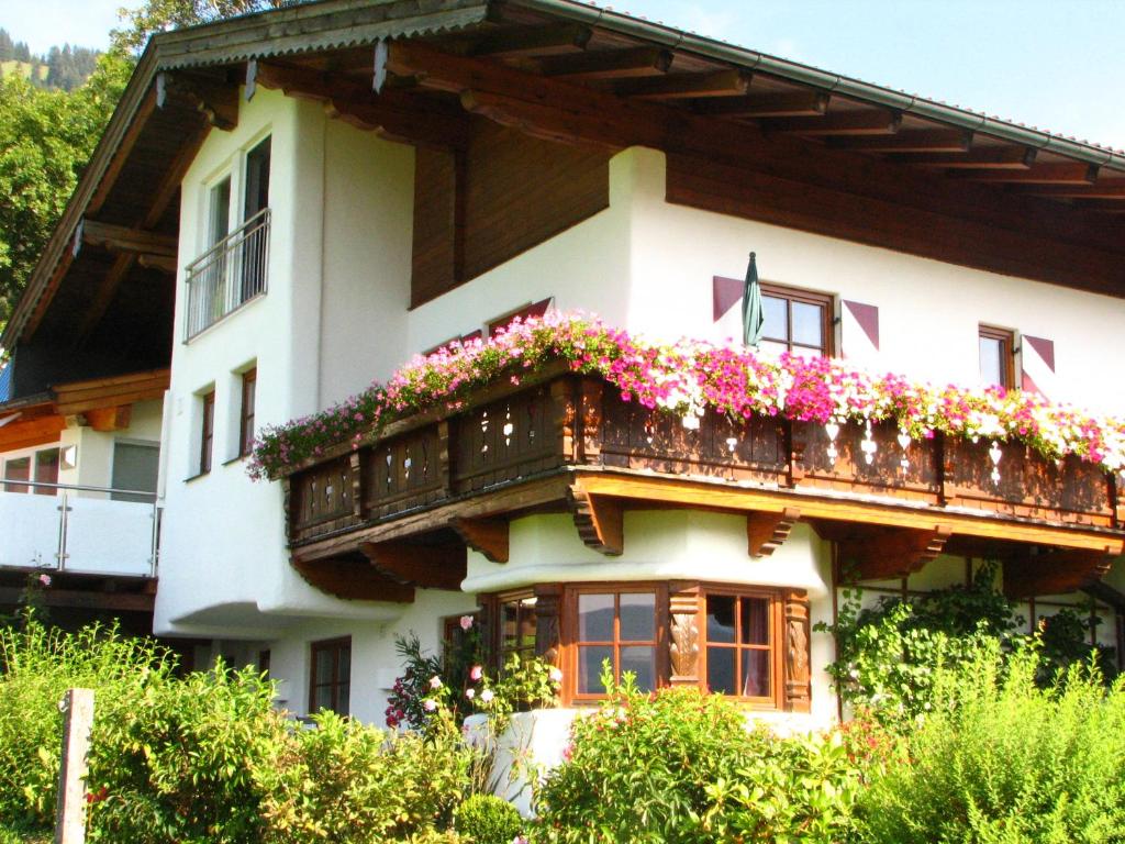 a house with a balcony with flowers on it at Appartement Lotte Familie Grünberger in Brixen im Thale