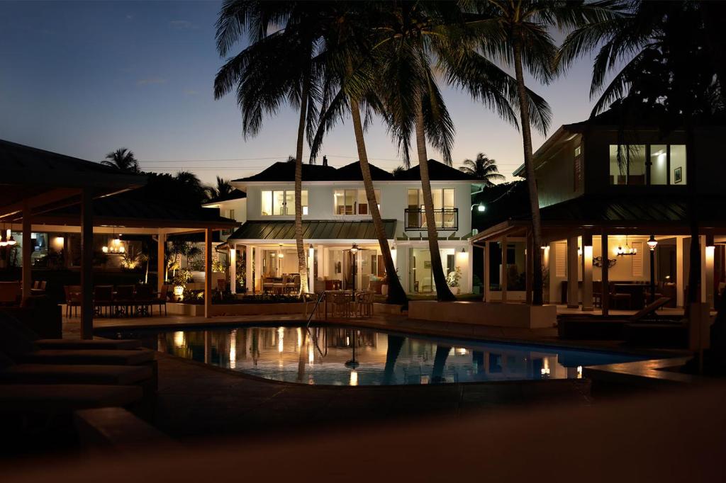 a building with a swimming pool in front of a house at Coral Cay Villas in Cherryfield