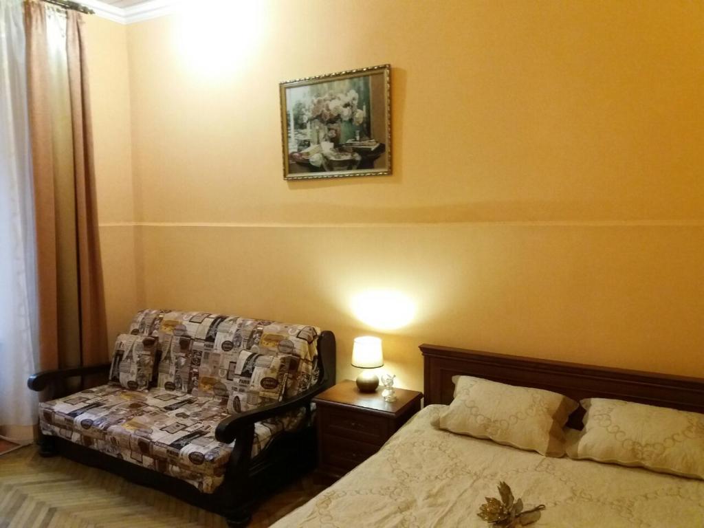 リヴィウにあるApartment on Ploshcha Svyatogo Teodoraのベッドルーム1室(ベッド1台付)が備わります。壁に絵が飾られています。