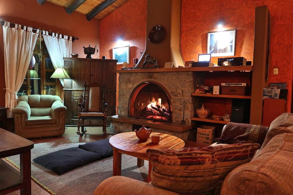 a living room with a fireplace and a couch at The Lazy Dog Inn a Mountain Lodge in Huaraz
