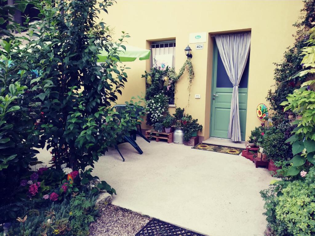 une terrasse couverte à l'avant avec une porte bleue et quelques plantes dans l'établissement B&B Peschi in Fiore, à Valeggio sul Mincio