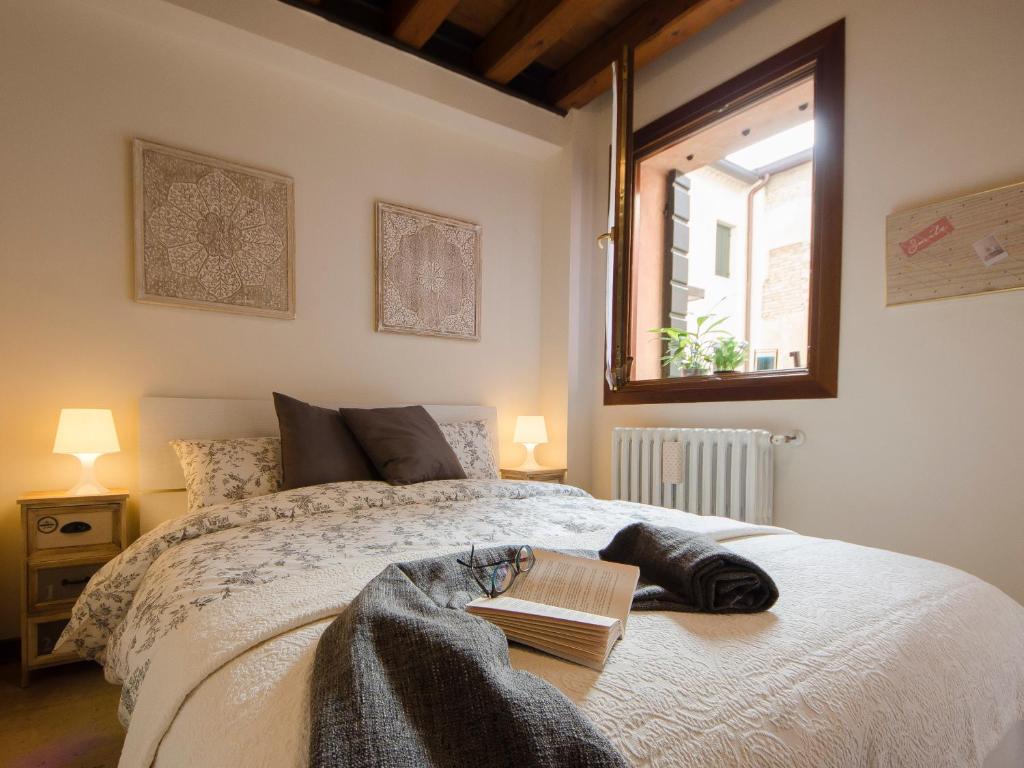 una camera da letto con un letto con un libro sopra di Il Salice a Treviso