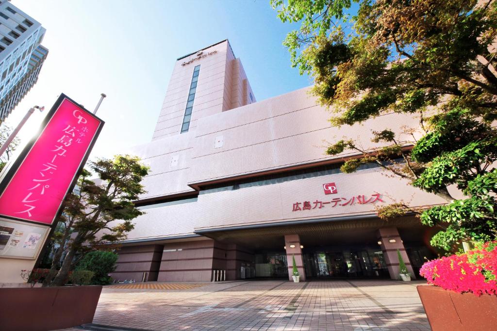 a large building with a sign in front of it at Hotel Hiroshima Garden Palace in Hiroshima