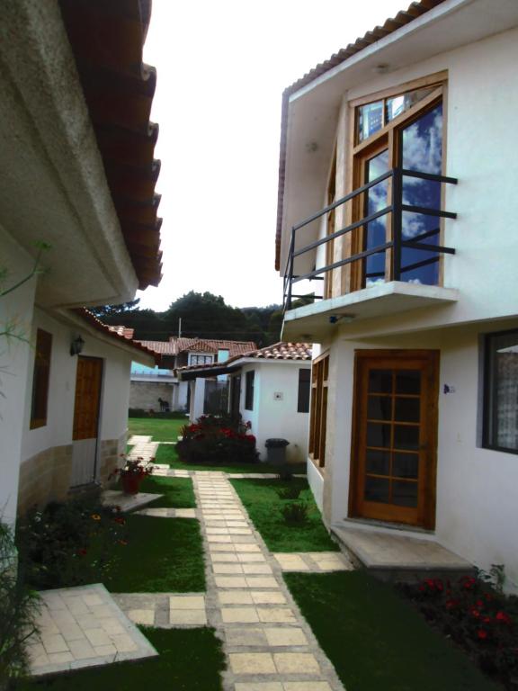 a white house with a balcony and a yard at San Jose Olympia in San Cristóbal de Las Casas