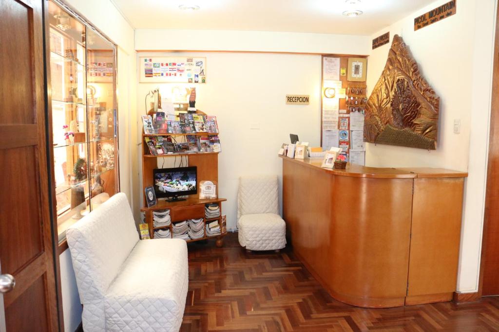 um quarto com duas cadeiras e um pódio numa loja em Picol Hostal em Cusco