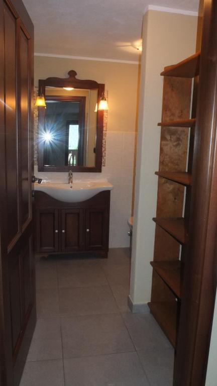 łazienka z umywalką i lustrem w obiekcie Maison de la Place w mieście Doues
