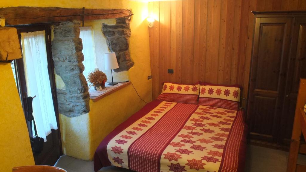 sypialnia z łóżkiem z czerwonym i żółtym kocem w obiekcie Maison de la Place w mieście Doues