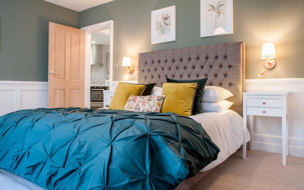 a bedroom with a large blue bed with yellow pillows at MyCityHaven Boutique Luxury in Bath City Centre in Bath
