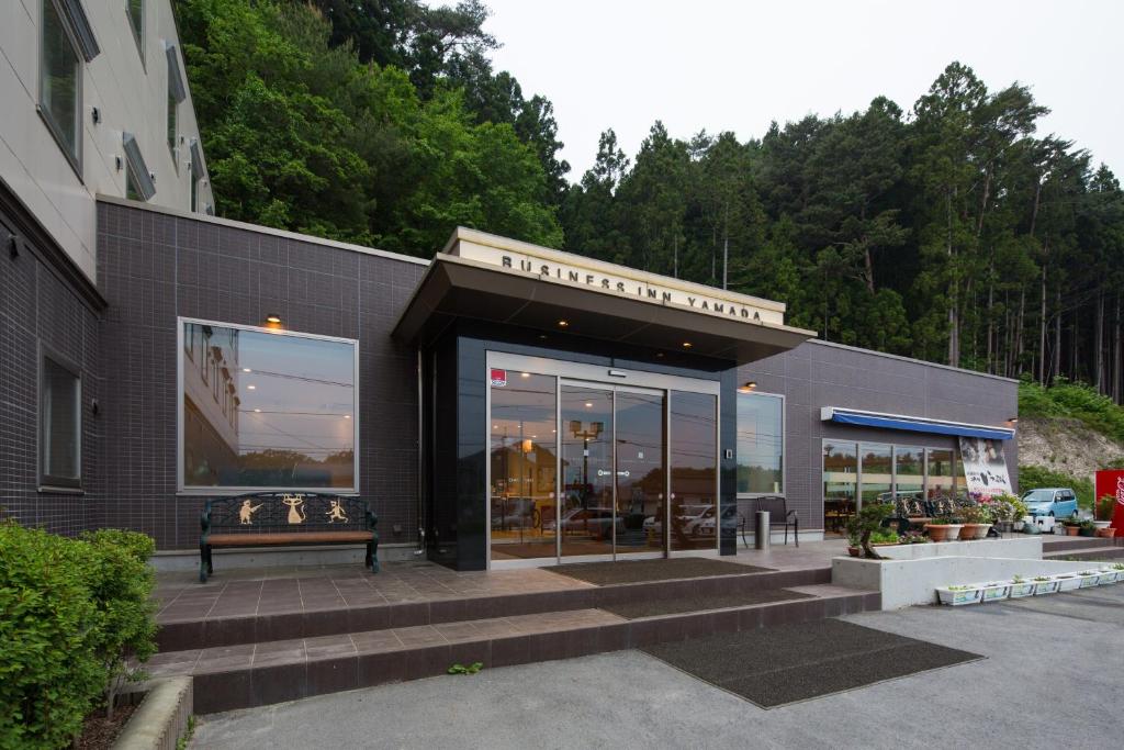 a building with a bench in front of it at Hotel Business Inn Yamada in Funakoshi