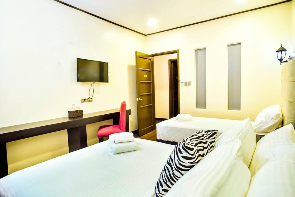 The Ambassador Hotel tesisinde bir odada yatak veya yataklar